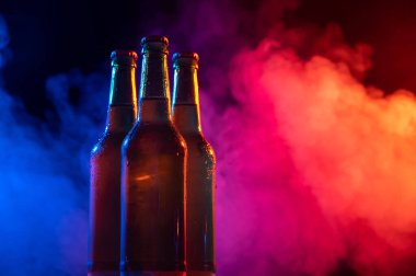 Mavi-pembe bir siste üç şişe bira..