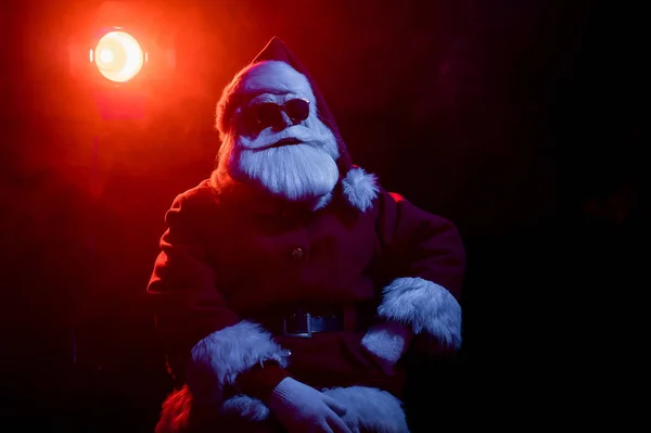 Santa claus en lunettes de soleil au néon sur fond noir. Fête de Noël. — Photo