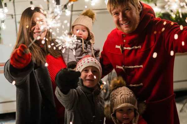 Glad stor familj firar jul i naturen och håller tomtebloss. Föräldrar med tre söner reser i husbil. — Stockfoto