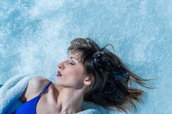 Close-up portrait of a caucasian woman lying on the snow. — Stock Photo, Image