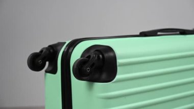 Bir kadın beyaz arka planda çekiçle bavula vuruyor..