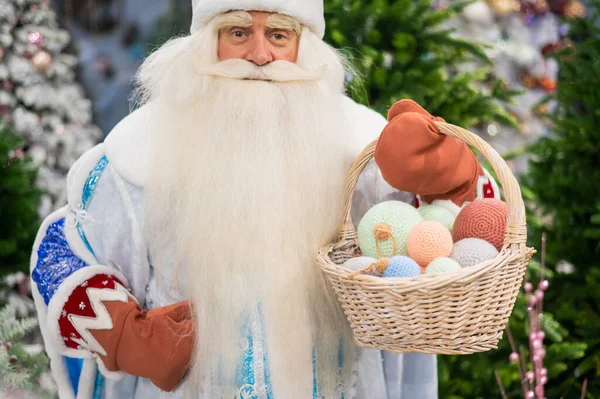 Russian santa claus holds decorations for the christmas tree in the store. — Stock Photo, Image