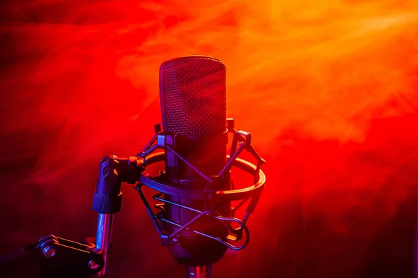 Professionele microfoon in rode rook op een zwarte achtergrond. — Stockfoto