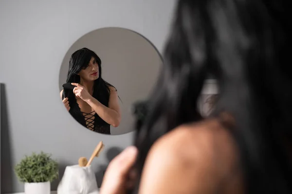 Homoseksualne żerowanie przed lustrem. Transeksualista czesający perukę. — Zdjęcie stockowe
