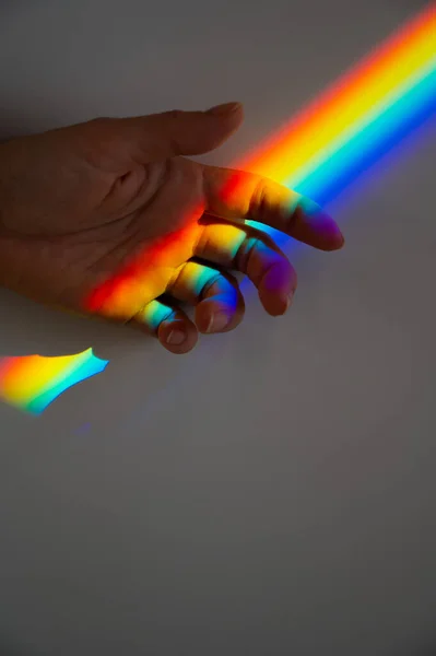 Raio de arco-íris em uma mão de mulheres. — Fotografia de Stock