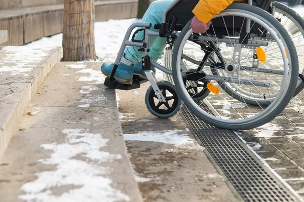 Vrouw in een rolstoel bij de trap in het park in de winter. — Stockfoto