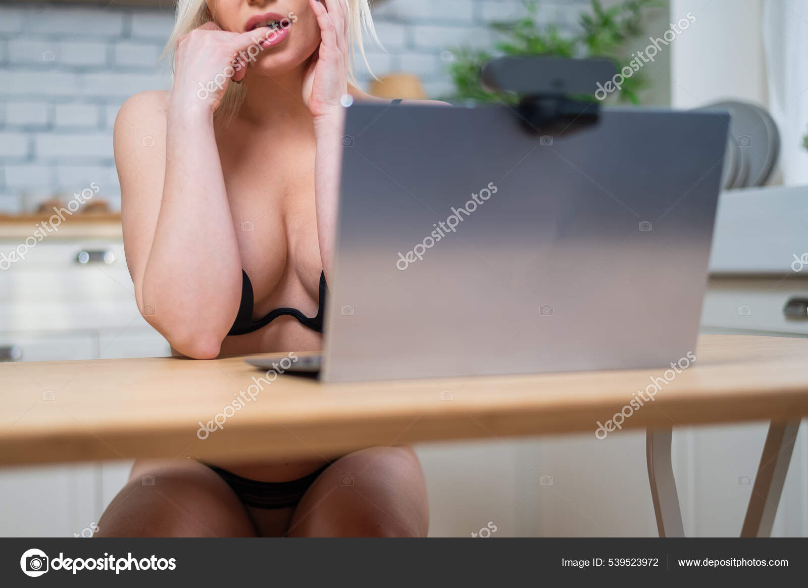 A girl in lingerie flirts on a webcam on a laptop