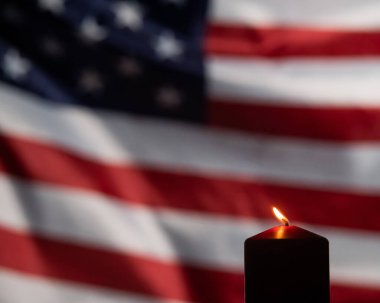 Amerika Birleşik Devletleri 'nin bayrağını sallayan arka planda yanan mum..