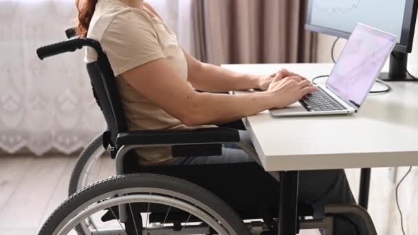 Кавказская женщина с ограниченными возможностями работает за компьютером, сидя в инвалидной коляске. — стоковое видео