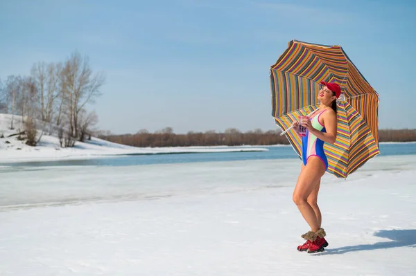 Caucasian woman in a swimsuit sunbathes on the snow in winter. — Zdjęcie stockowe