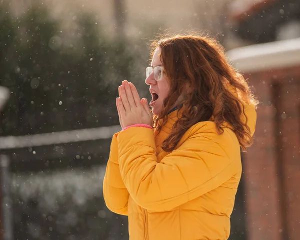 Kaukasiska rödhåriga kvinna fryser i frosten utomhus. Snöfall på vintern. — Stockfoto