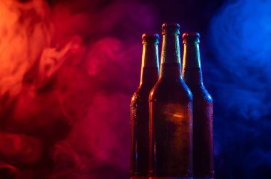 Mavi-pembe bir siste üç şişe bira..