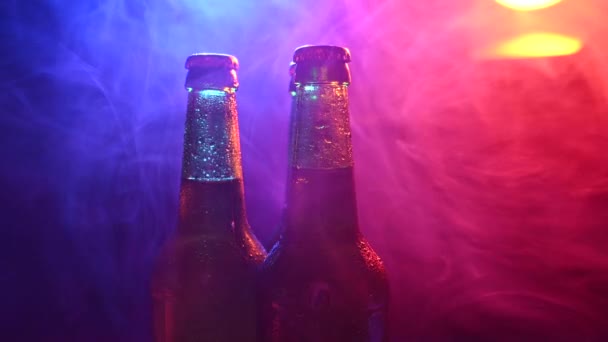 Tiga botol bir berputar dalam kabut merah muda biru. — Stok Video