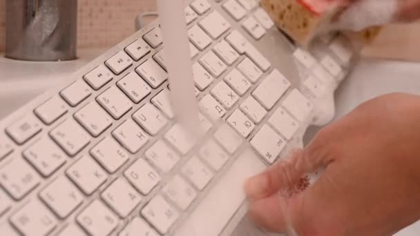 Wanita mencuci keyboard komputer putih dengan spons dengan busa. — Stok Video