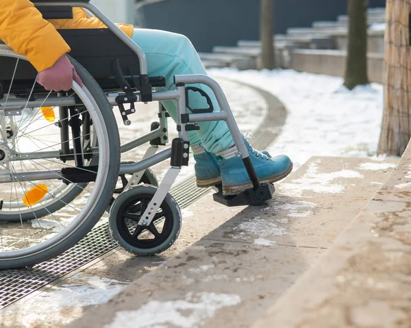 Woman in a wheelchair near the stairs in the park in winter. — Stock Photo, Image