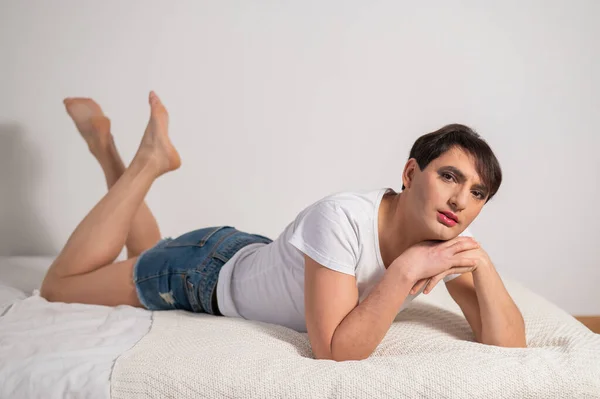 Kaukasischer Transgender-Mann liegt auf Schwulenbett Draußen gay posieren im die schlafzimmer. — Stockfoto