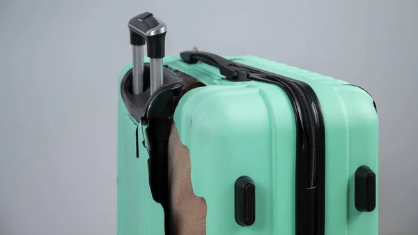 Primer plano de una maleta de plástico rota sobre un fondo blanco. —  Fotos de Stock