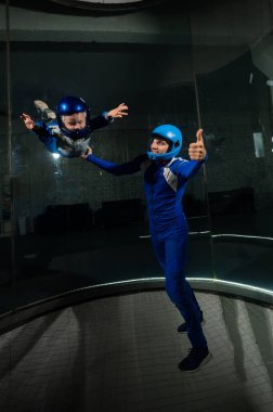 Bir adam bir çocuğa rüzgar tünelinde uçmayı öğretiyor. Yerçekimi eksikliği.