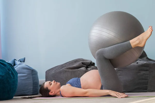 Embarazada mujer caucásica en forma con una pelota. Yoga para embarazadas. Niña en el aula en preparación para el parto. Pilates en el último trimestre. —  Fotos de Stock