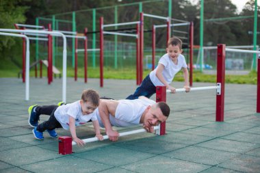 Beyaz bir adam spor için oğullarıyla birlikte sahaya çıkar..