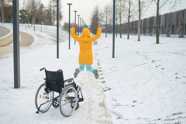 Felice donna caucasica alzata dalla sedia a rotelle e saltare. Ragazza felice recupera e inizia a camminare di nuovo. — Foto Stock
