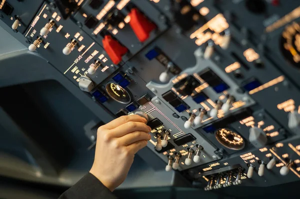 Close-up of a pilots hand turning a toggle switch on the control panel. — Stock Photo, Image