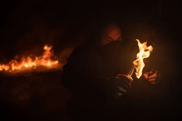 Maskeli bir adam yanan bir şişe tutuyor. Molotof kokteyli. — Stok fotoğraf