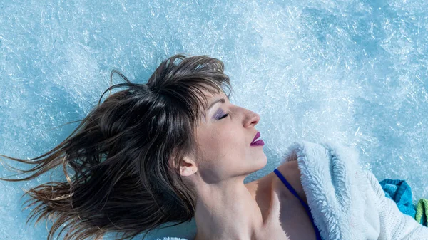 Close-up portrait of a caucasian woman lying on the snow. — Stock Photo, Image