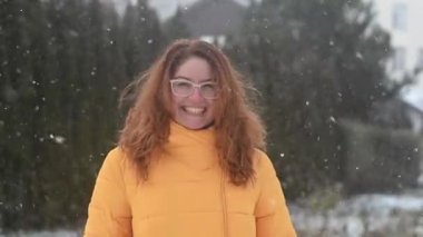 Kızıl saçlı beyaz kadın ilk kar yağdığında sevinir..