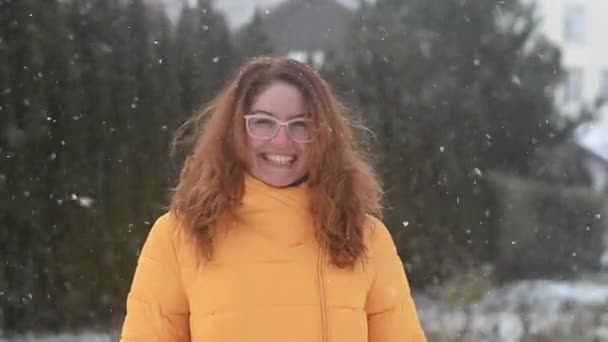 Rudowłosa biała kobieta raduje się z pierwszego śniegu. — Wideo stockowe