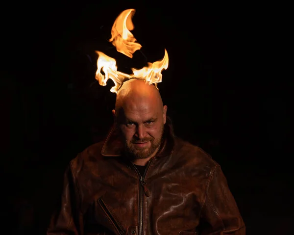 一个秃头的男人，穿着皮夹克，头上带着燃烧的笑容. — 图库照片