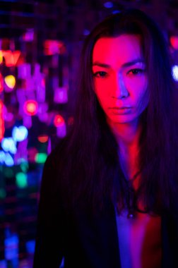 Bir androjenik modelin yakın plan portresi. Stüdyoda neon ışıklı bir erkek transseksüel..