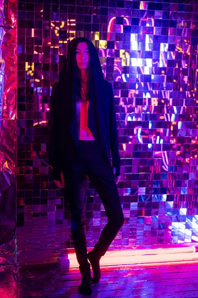 Modelo androgénico num capuz. Masculino transexual em estúdio com luz de néon. — Fotografia de Stock