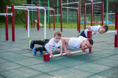 Beyaz bir adam spor için oğullarıyla birlikte sahaya çıkar..