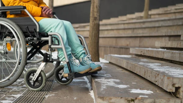 Woman in a wheelchair near the stairs in the park in winter. — Stock Photo, Image