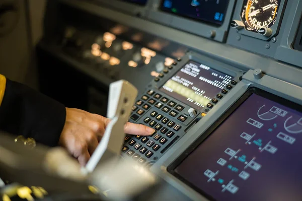 Kadın pilot uçuş bilgilerini uçak sistemine yerleştiriyor. Uçak kontrol paneli. — Stok fotoğraf