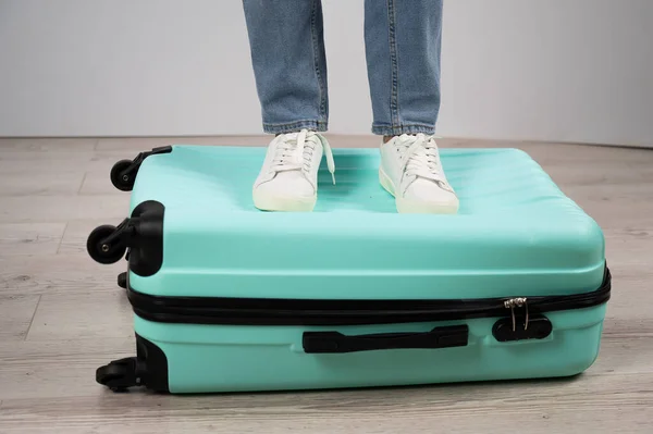 Vrouw met haar voeten op een koffer. — Stockfoto