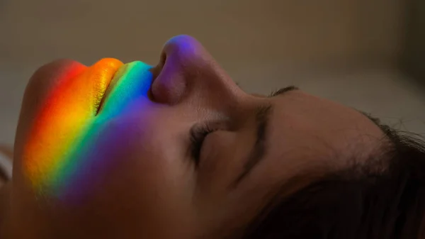 Close-up portrait of caucasian woman with ray of rainbow light on her face. — Fotografia de Stock