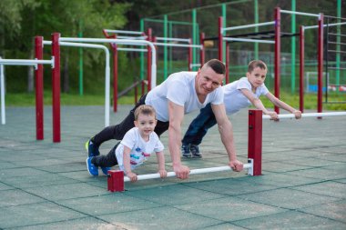 Beyaz bir adam spor için oğullarıyla birlikte sahaya çıkar..