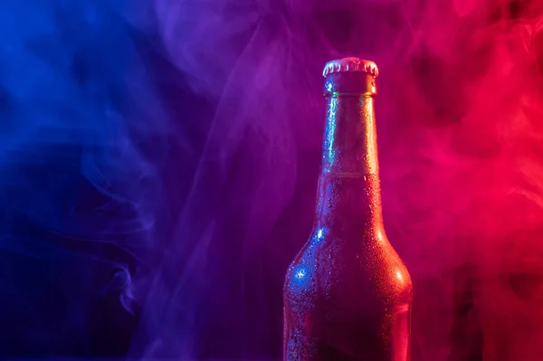 Skleněná láhev piva v modré růžové mlze — Stock fotografie