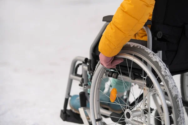 Close-up of hands of a disabled woman in a wheelchair outdoors in winter. — 图库照片