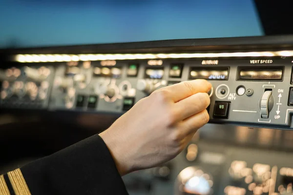 Close-up of a pilots hand on an airplane control panel. — Stock Photo, Image