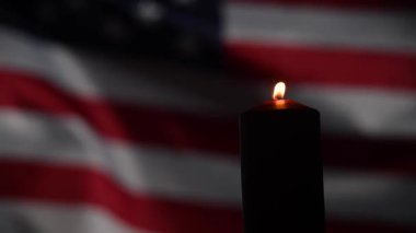 Amerika Birleşik Devletleri 'nin bayrağını sallayan arka planda yanan mum..
