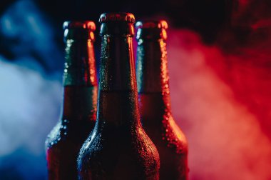 Mavi-pembe bir siste üç şişe bira..