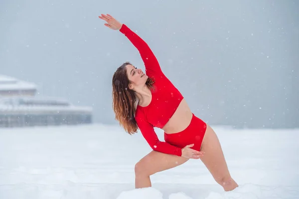 Donna caucasica vestita in pantaloncini rossi e top fare yoga all'aperto in inverno. — Foto Stock