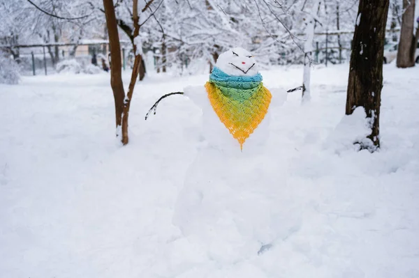 Pupazzo di neve vestito con una sciarpa all'uncinetto. Divertimento invernale. — Foto Stock