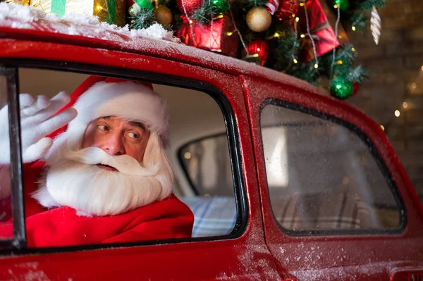 Retrato de Papai Noel dirigindo um carro vermelho para o Natal. — Fotografia de Stock