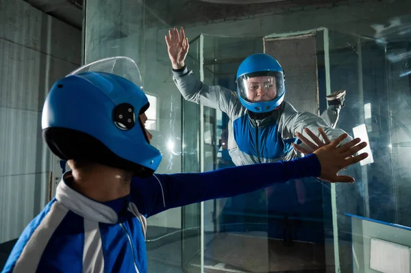 Un hombre entrena a una mujer como astronauta. Clases sobre volar en un túnel de viento. — Foto de Stock