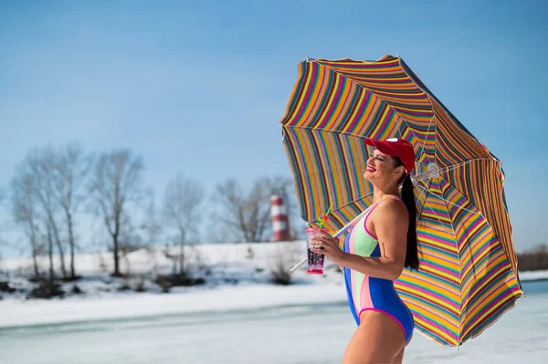Caucasian woman in a swimsuit sunbathes on the snow in winter. — Fotografia de Stock