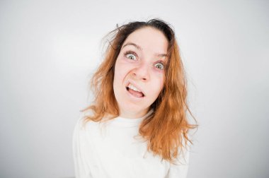 Beyaz arka planda deli gömlekli deli kadının yakın plan portresi..